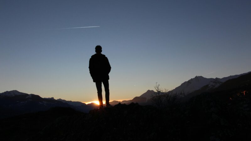 Silhouette of a boy standing on a hilltop